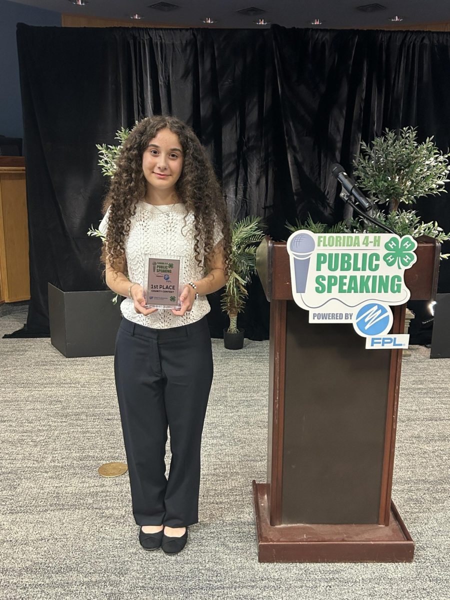 Mila holds her award after her speech won at the district competition.