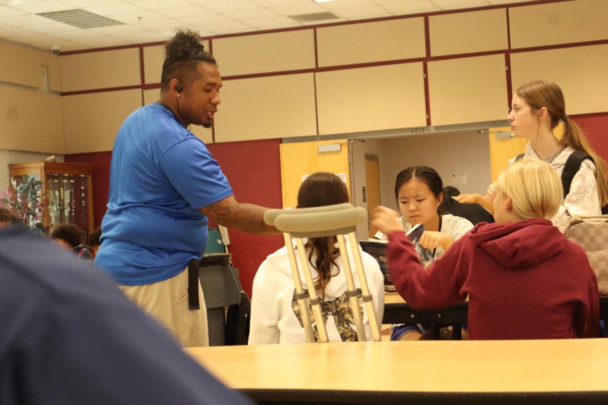 Mr. Kenny fistbumps students in the cafeteria.