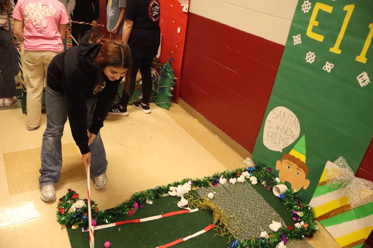 Quinn Dozier playing candy cane mini golf with her friends at the ELF hole. 