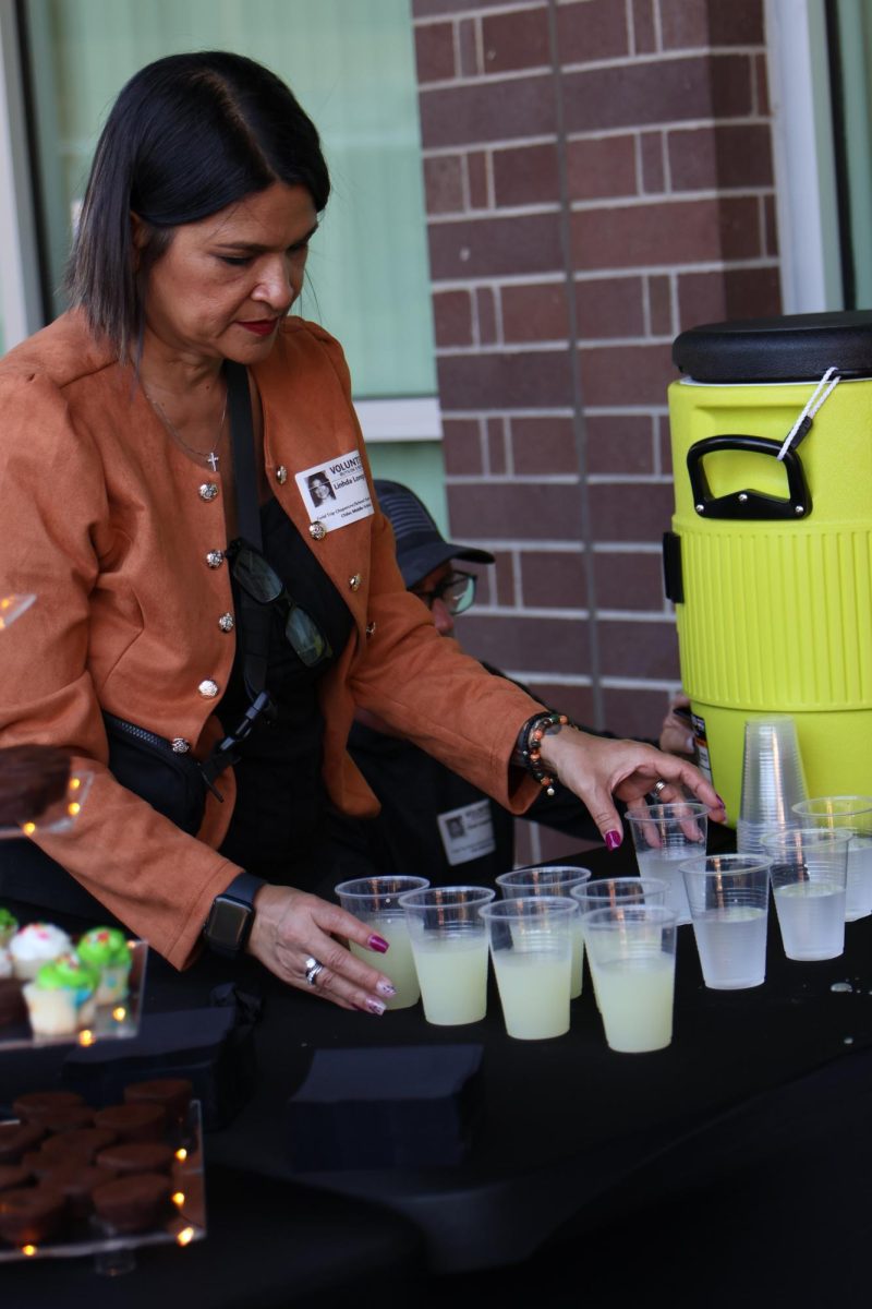 A volunteer keeps up the refreshments at the 8th grade dance.