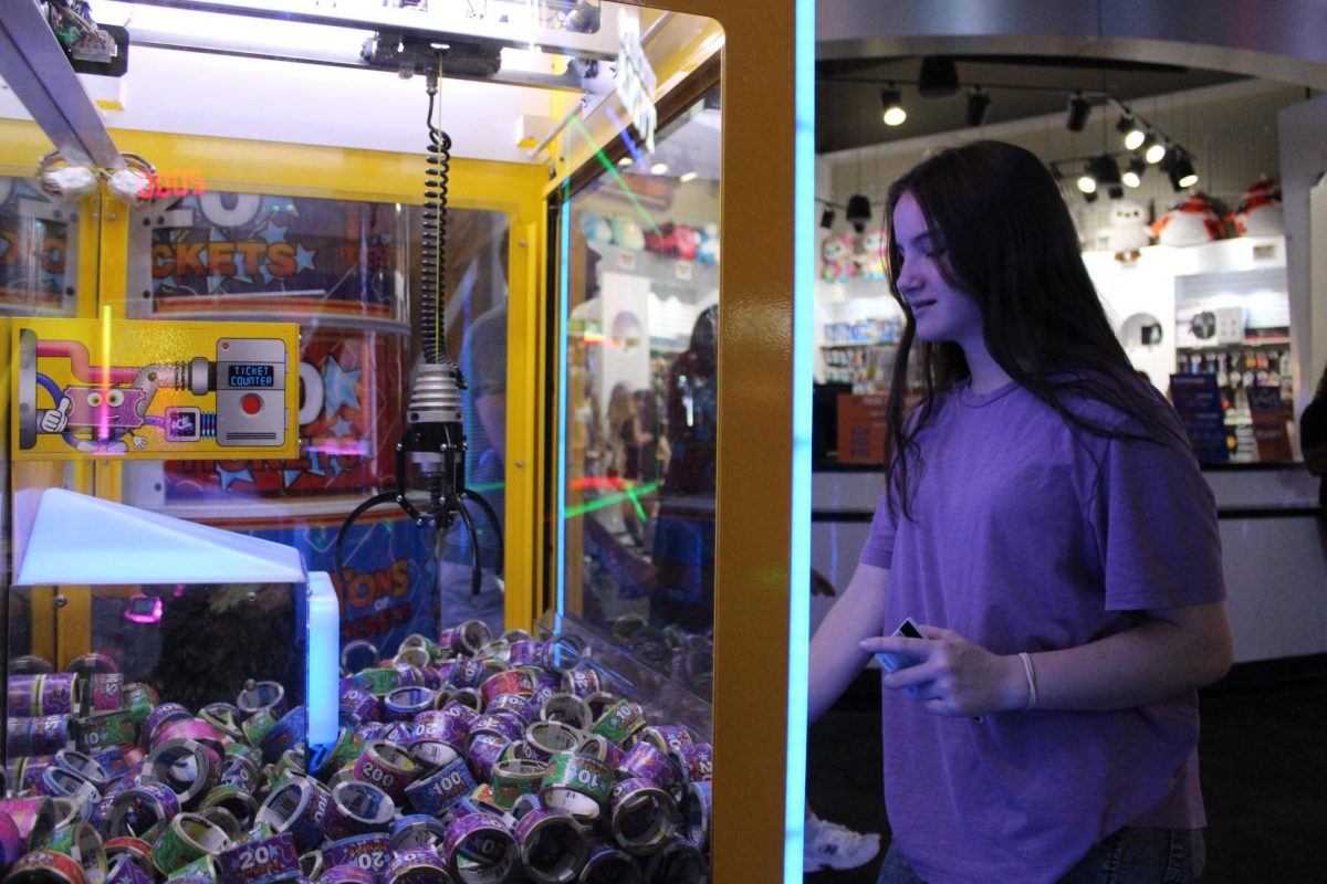 Grab your ticket rolls! In this photo, Katelyn Jacob (7th) tries her luck at a claw machine where you try to grab ticket rolls to earn points. Tho it is a hard game, she still won a few times.