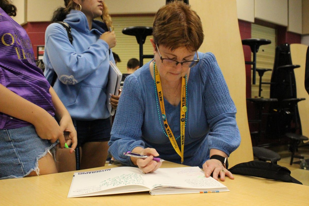 Mrs Brady signs a students yearbook.