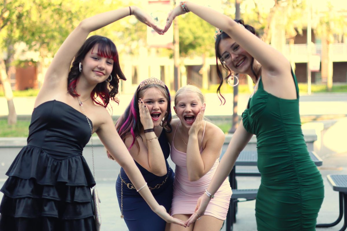 At  the 8th grade dance Reese Blabek, Ana Grigoletti Domit, Payten Robilard, and Sophia Thomas pose for the camera.
