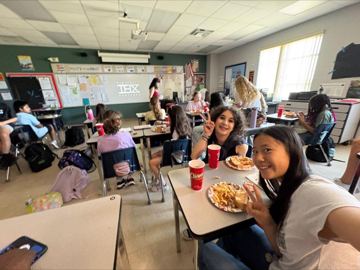 At the Student Government party at the end of the year, Mila Kiray (7) and Kendall Truong (8) take a selfie while eating Caines.