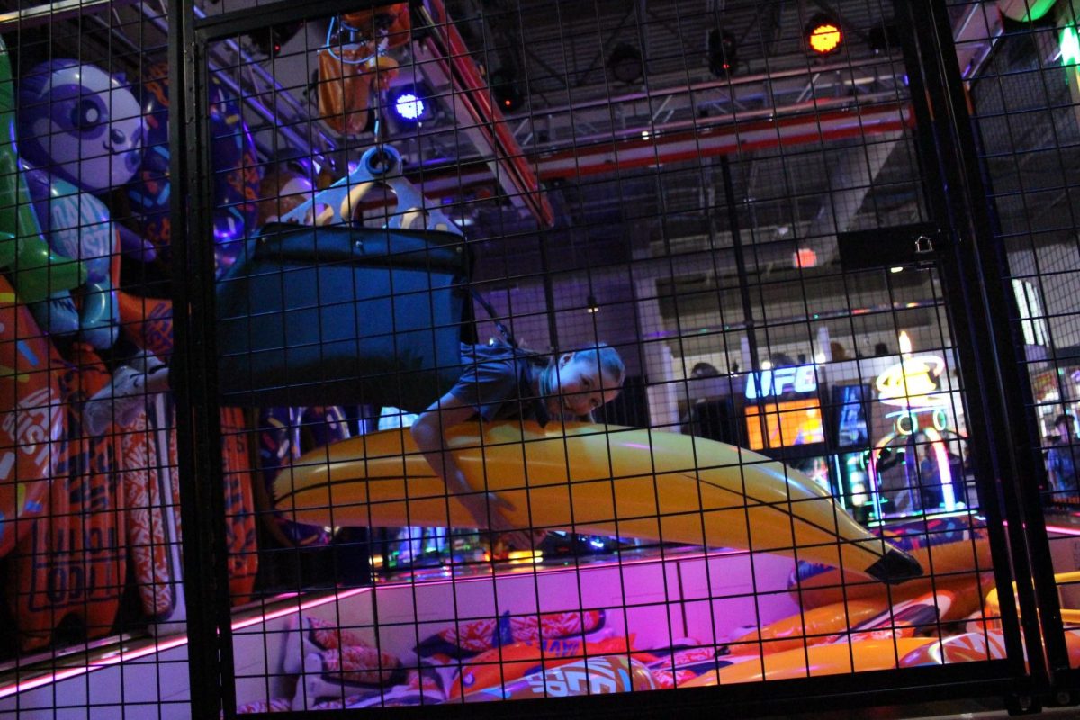 Have you ever wanted to be the claw of a claw machine? One game at Dave and Busters was called "Human Crane", where they suspend you in the air and you grab a prize, just like a real claw machine. In the photo, Reese Oppelt (7th) grabbed an inflatable banana as her prize while being the claw of the claw machine. 