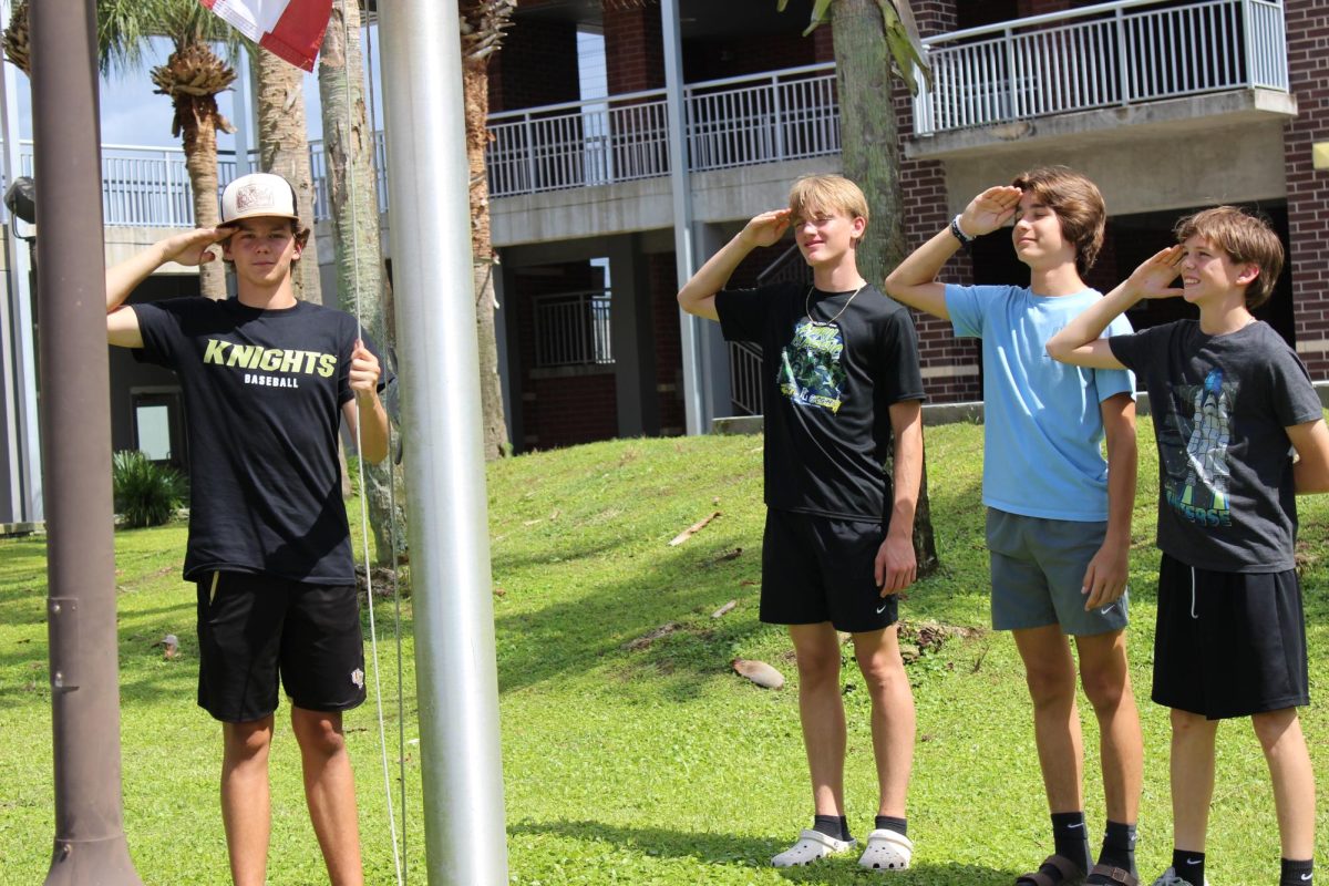 All four boys salute the flag at the end of the day, before folding it up.