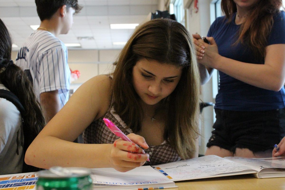 Quinn Dozier (8) is signing all her friend's yearbooks before highschool.