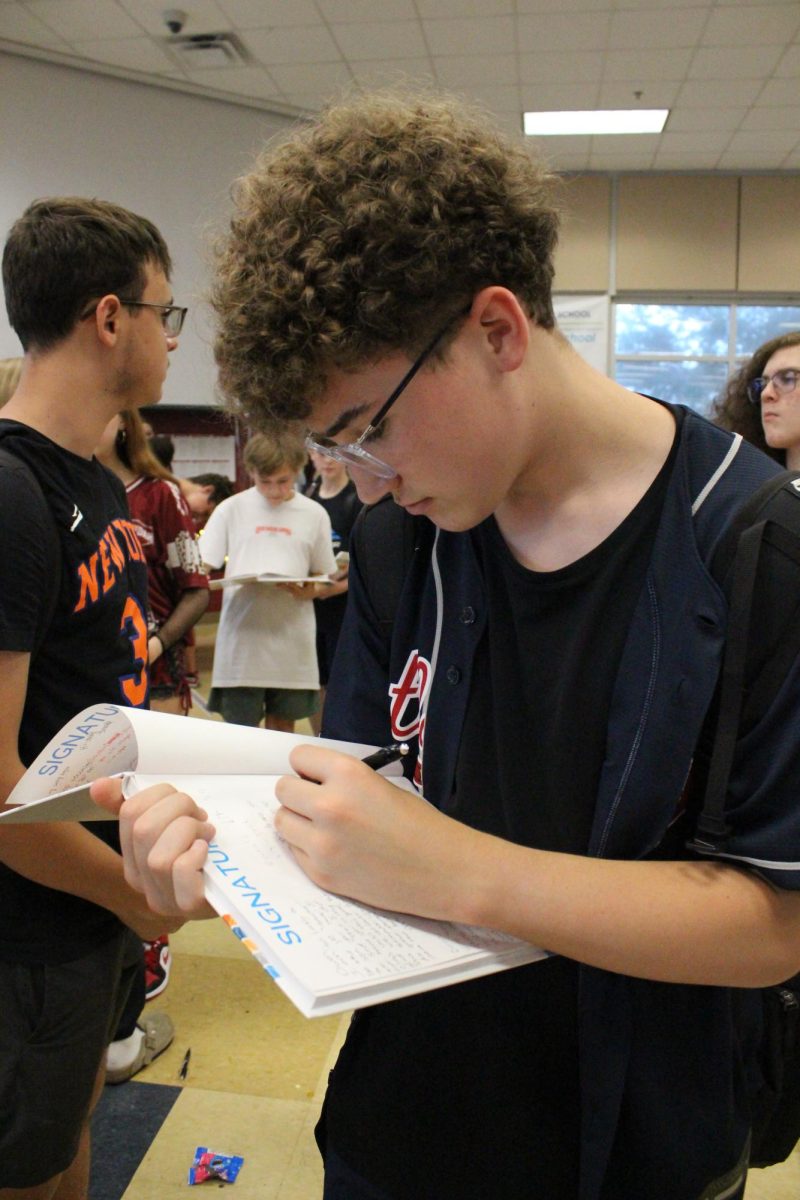 Gavin Lovelady (8) is making sure to sign all his friend's yearbooks before the party is over.