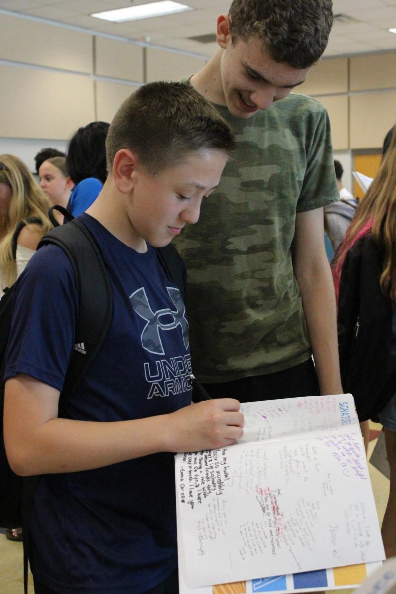 Luke Coyle (8) is signing his friends yearbooks.